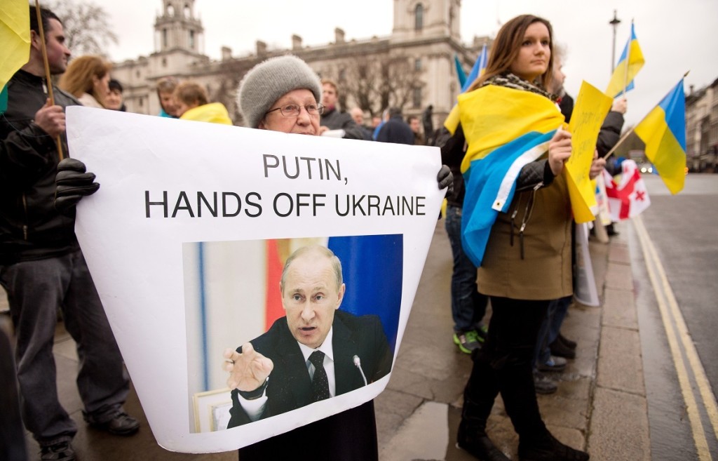 Protestantes con carteles contra la intervención de Putin en Ucrania ©AFP PHOTO / LEON NEAL