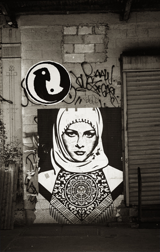 Arte callejero en la pared de una calle. Representada aparece una mujer musulmana con hiyab. cc Randy Lemoine