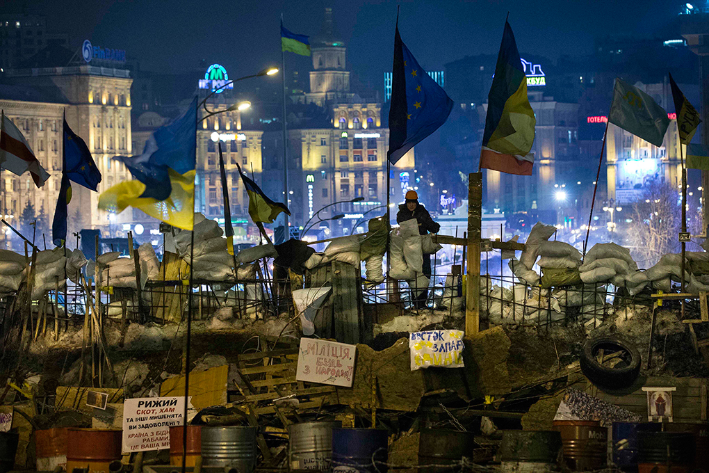 Un activista de la Unión Pro-Europea vigila la cima de las barricadas que rodean un campamento fortificado durante un mitin en la Plaza de la Independencia en Kiev, Ucrania, Martes, 17 de diciembre 2013. AP PHOTO/ALEXANDER ZEMLIANICHENKO